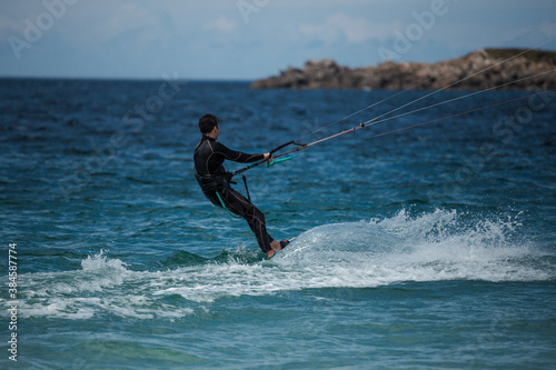 A man is pulled out of the water by his kite while kitesurfing