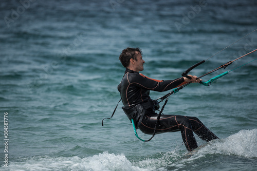 A man is pulled out of the water by his kite while kitesurfing