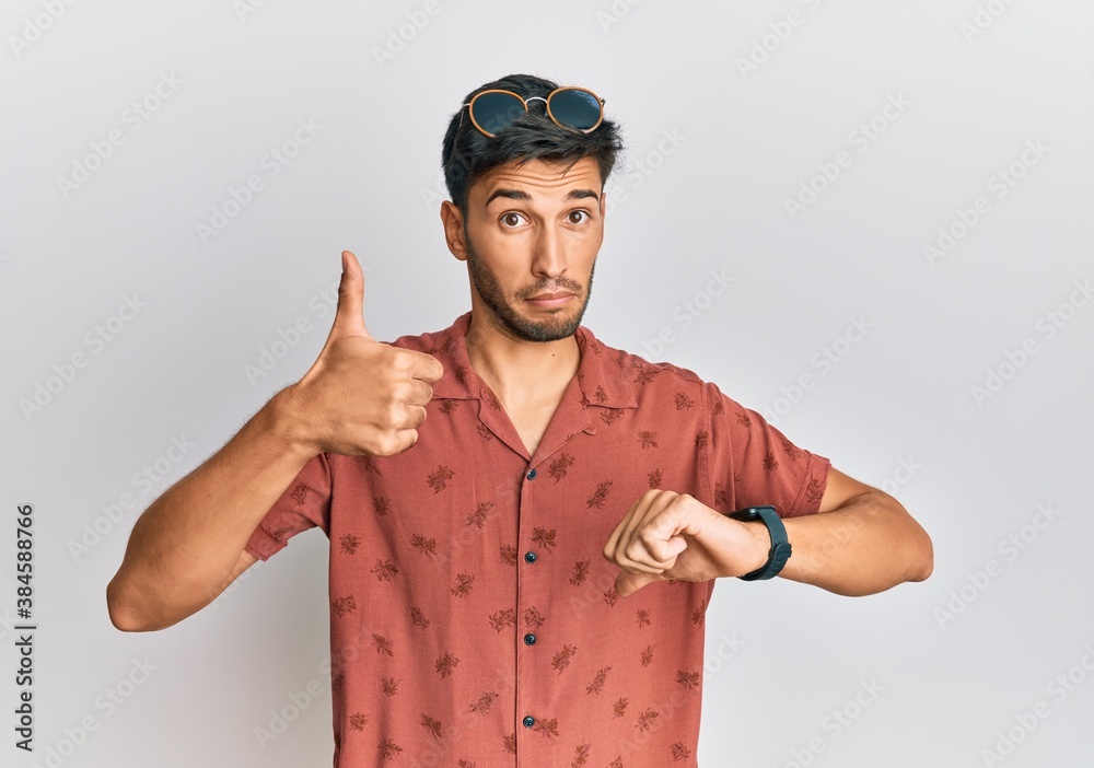 Young handsome man wearing casual summer clothes doing thumbs up and down, disagreement and agreement expression. crazy conflict Young handsome man wearing casual summer clothes doing thumbs up and down, disagreement and agreement expression. crazy conflict
