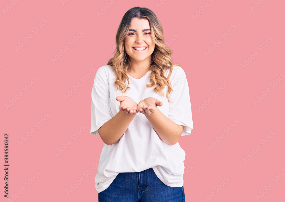 Young caucasian woman wearing casual clothes smiling with hands palms together receiving or giving gesture. hold and protection Young caucasian woman wearing casual clothes smiling with hands palms together receiving or giving gesture. hold and protection