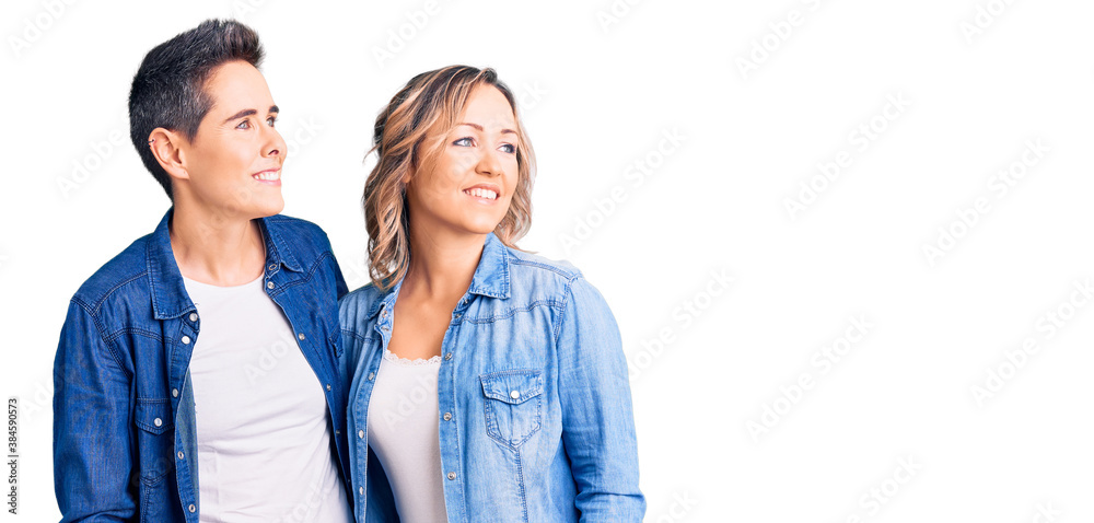 Couple of women wearing casual clothes looking away to side with smile on face, natural expression. laughing confident. Couple of women wearing casual clothes looking away to side with smile on face, natural expression. laughing confident.