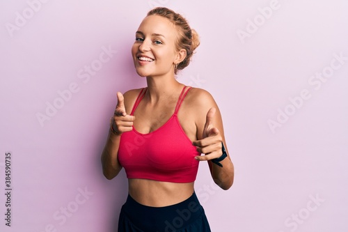 Beautiful caucasian woman wearing sportswear pointing fingers to camera with happy and funny face. good energy and vibes. © Krakenimages.com