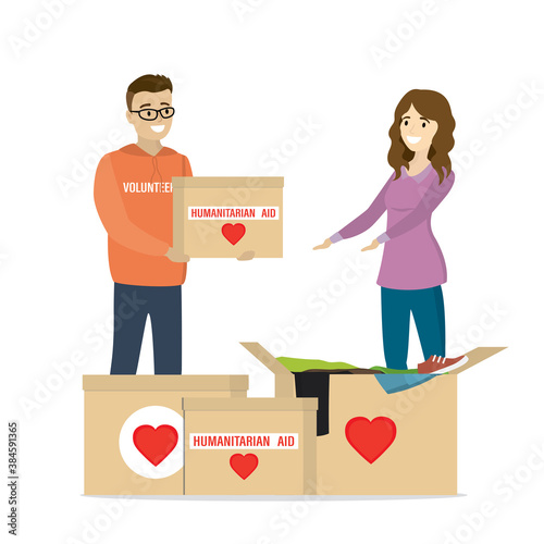 Caucasian man volunteer gives woman box of humanitarian aid. Charity donation concept, second hand things.