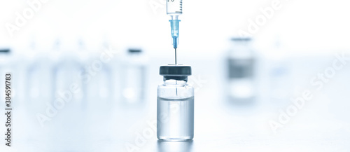 Medical syringe with a needle and a bollte with vaccine.