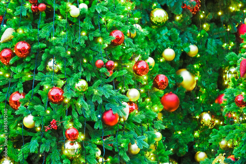New Year greeting concept. Christmas green background. Christmas trees decorated with red and golden decorations and lights, garlands and toys. Illumination