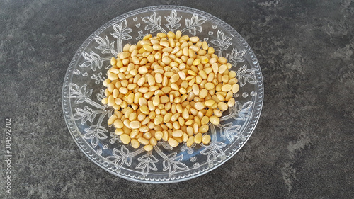 pine nuts on a plate against a dark background