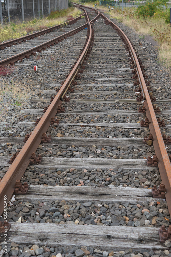 Background of old rusty curved rails in a gravel bedding on an abandoned factory premises Background of old rusty curved rails in a gravel bedding on an abandoned factory premises