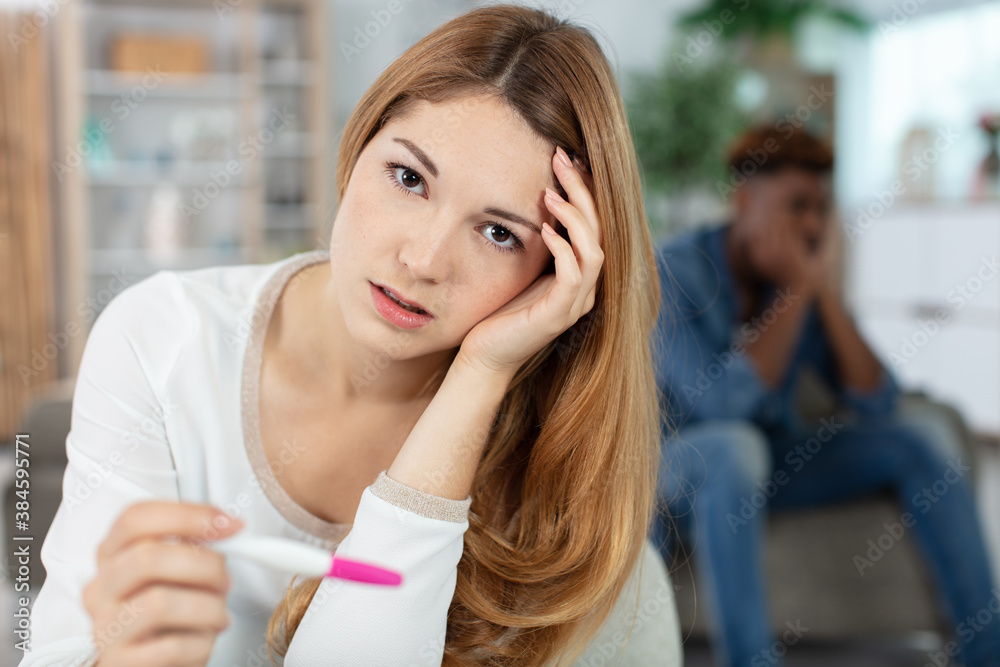 single sad woman complaining holding a pregnancy test