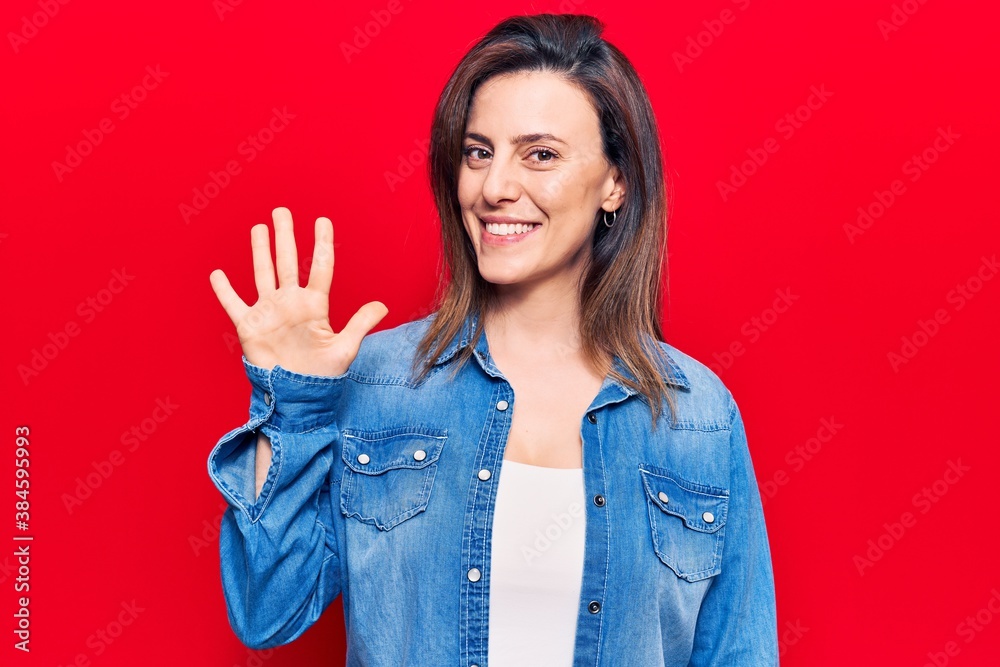 Young beautiful woman wearing casual clothes showing and pointing up with fingers number five while smiling confident and happy. Young beautiful woman wearing casual clothes showing and pointing up with fingers number five while smiling confident and happy.