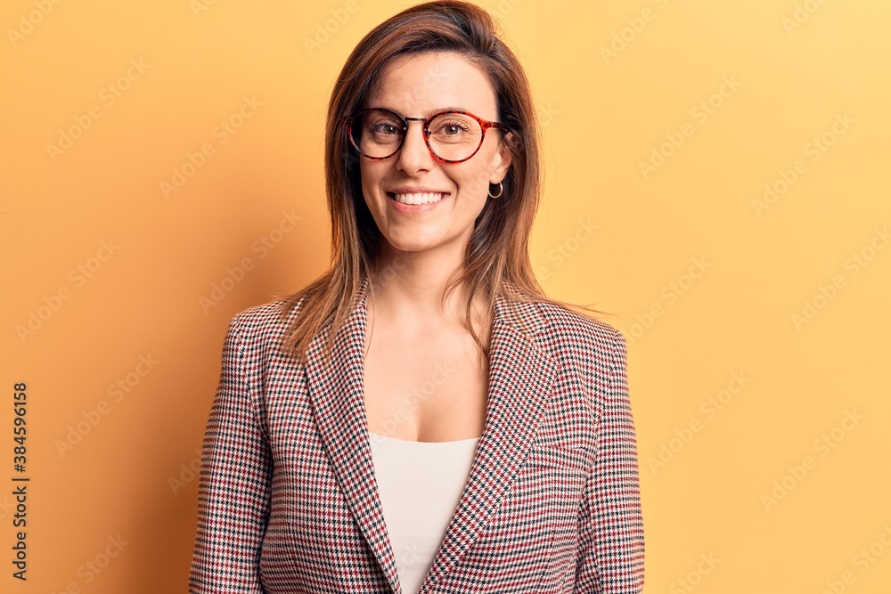 Young beautiful woman wearing business clothes and glasses looking positive and happy standing and smiling with a confident smile showing teeth