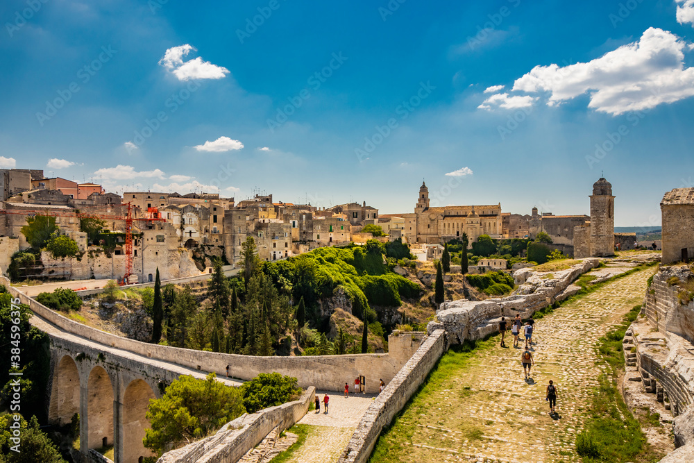 Gravina in Puglia, Italy. The stone bridge, ancient aqueduct and viaduct. Across the valley the skyline of the city with its houses and buildings and the cathedral at the bottom.