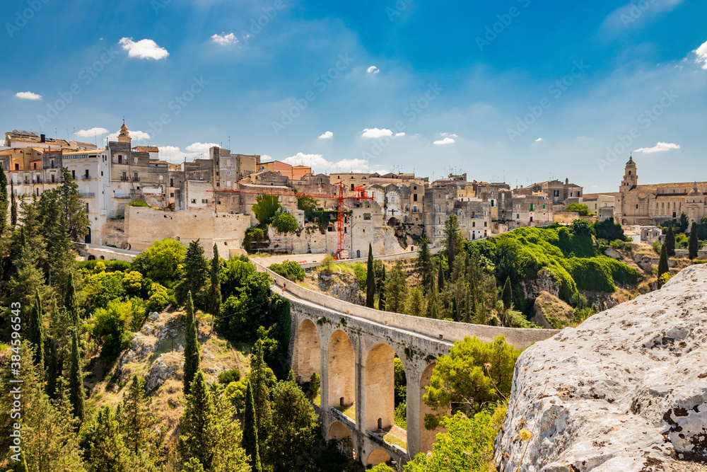 Gravina in Puglia, Italy. The stone bridge, ancient aqueduct and viaduct. Across the valley the skyline of the city with its houses and buildings and the cathedral at the bottom.