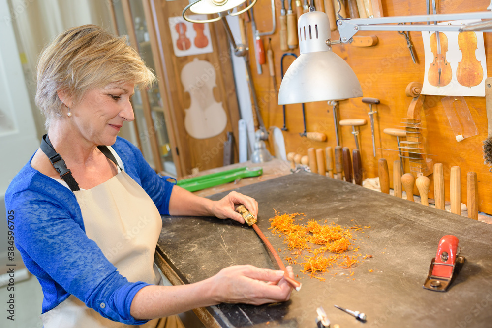 female luthier working on the creation of a violin
