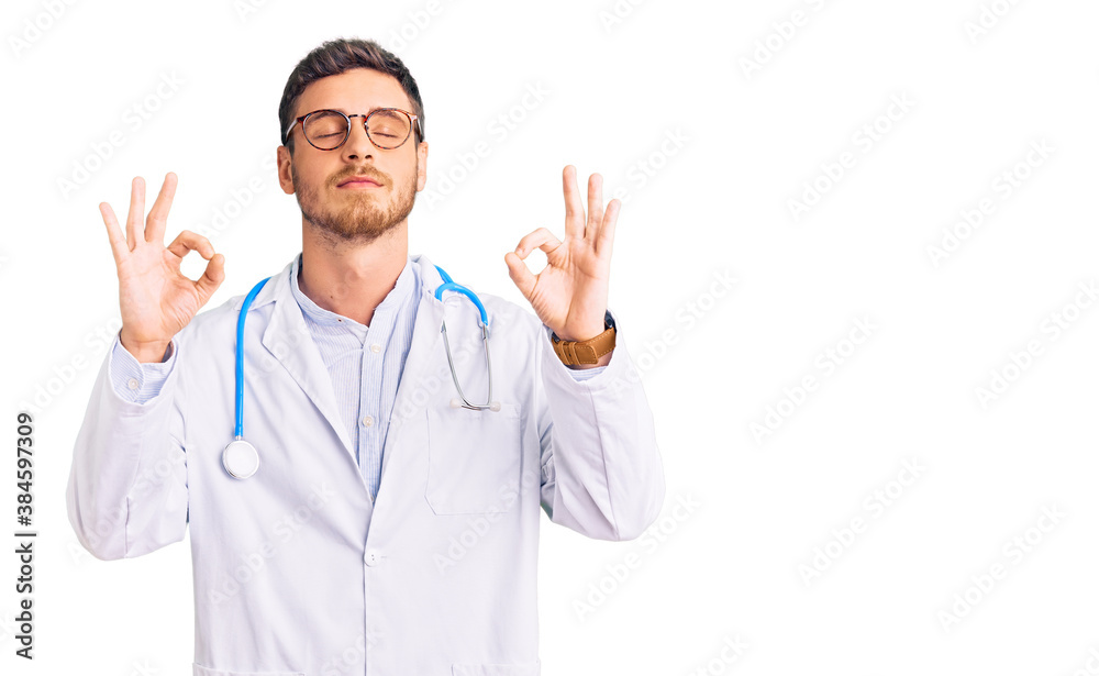 Handsome young man with bear wearing doctor uniform relax and smiling with eyes closed doing meditation gesture with fingers. yoga concept. Handsome young man with bear wearing doctor uniform relax and smiling with eyes closed doing meditation gesture with fingers. yoga concept.