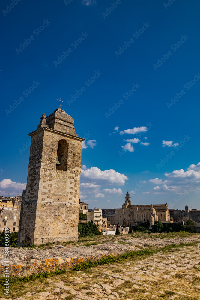 Gravina in Puglia, Italy. The path of pebbles and stones that leads to the Sanctuary of Madonna della Stella, with its bell tower and the ancient cave church carved into the rock. Gravina in Puglia, Italy. The path of pebbles and stones that leads to the Sanctuary of Madonna della Stella, with its bell tower and the ancient cave church carved into the rock.