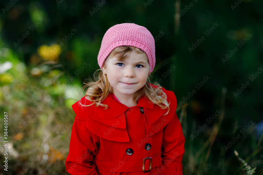 Cute little toddler girl in red coat making a walk through autumn forest. Happy healthy baby enjoying walking with parents. Sunny fall day with child. Active leisure and activity with kids in nature. Cute little toddler girl in red coat making a walk through autumn forest. Happy healthy baby enjoying walking with parents. Sunny fall day with child. Active leisure and activity with kids in nature.
