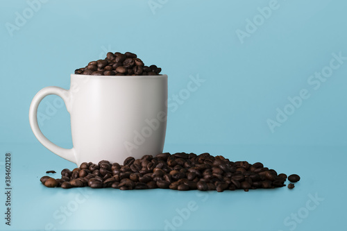 Blank white cup full of coffee beans. White mockup