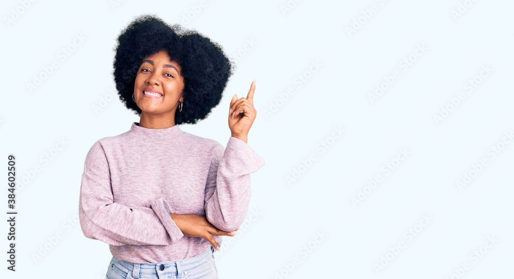 Young african american girl wearing casual clothes with a big smile on face, pointing with hand and finger to the side looking at the camera. Young african american girl wearing casual clothes with a big smile on face, pointing with hand and finger to the side looking at the camera.