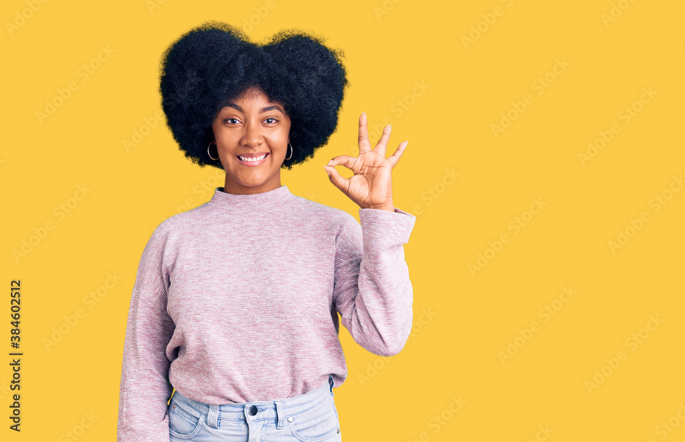 Young african american girl wearing casual clothes smiling positive doing ok sign with hand and fingers. successful expression. Young african american girl wearing casual clothes smiling positive doing ok sign with hand and fingers. successful expression.