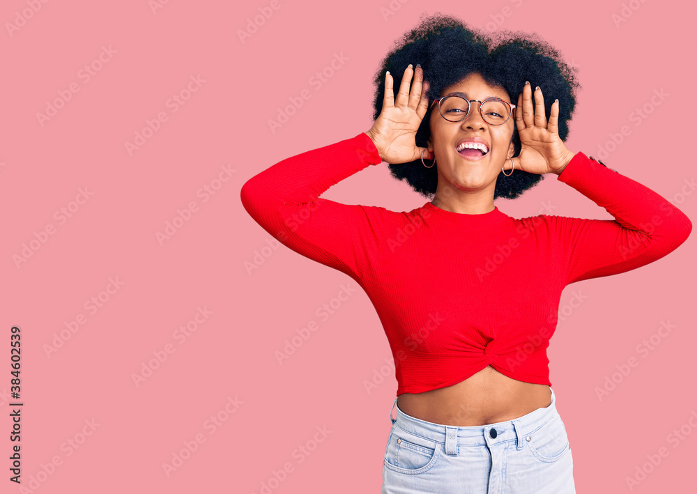 Young african american girl wearing casual clothes and glasses smiling cheerful playing peek a boo with hands showing face. surprised and exited Young african american girl wearing casual clothes and glasses smiling cheerful playing peek a boo with hands showing face. surprised and exited