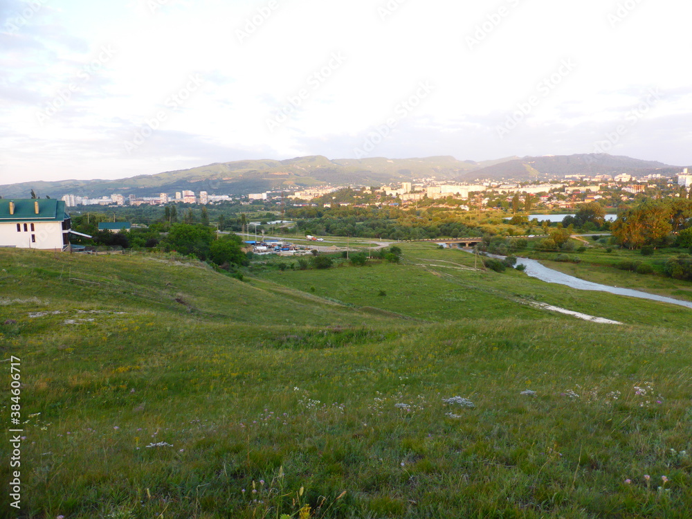 Grass, valley, horizon. View of the city of Kislovodsk