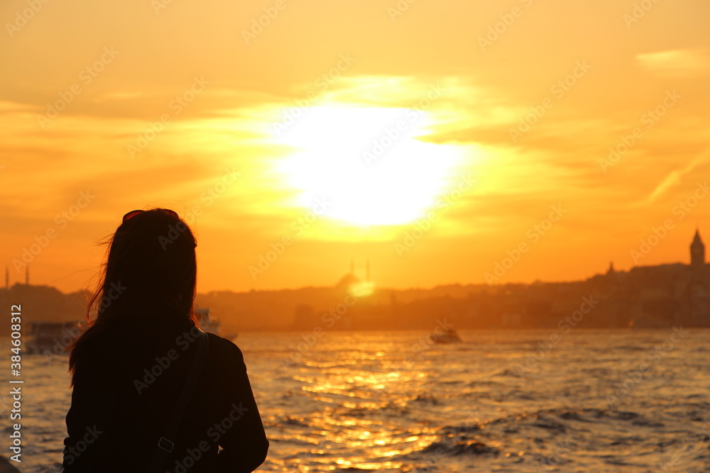 Silhouette of a woman looking to the Istanbul at sunset