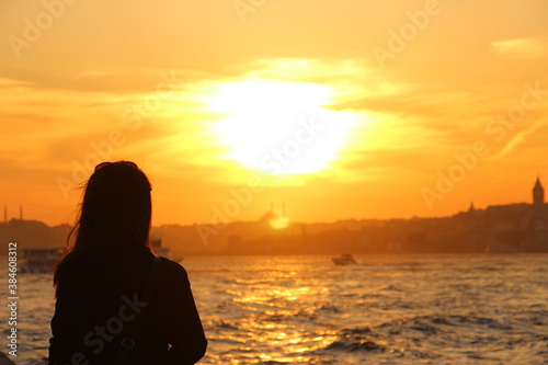 Silhouette of a woman looking to the Istanbul at sunset © senerdagasan