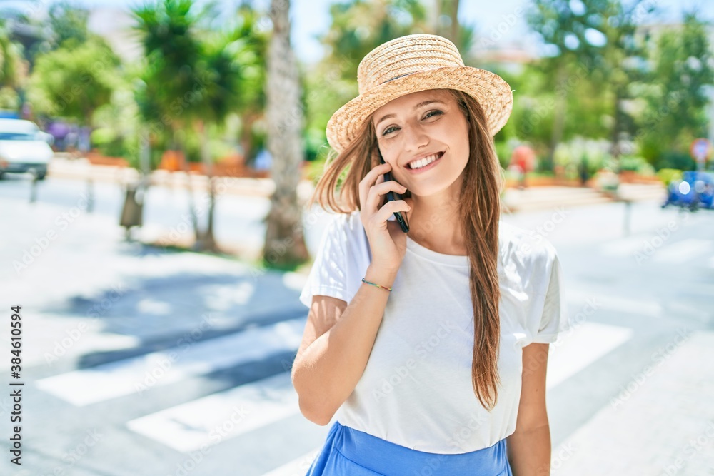 Young blonde woman on vacation smiling happy having conversation talking on the smartphone at street of city