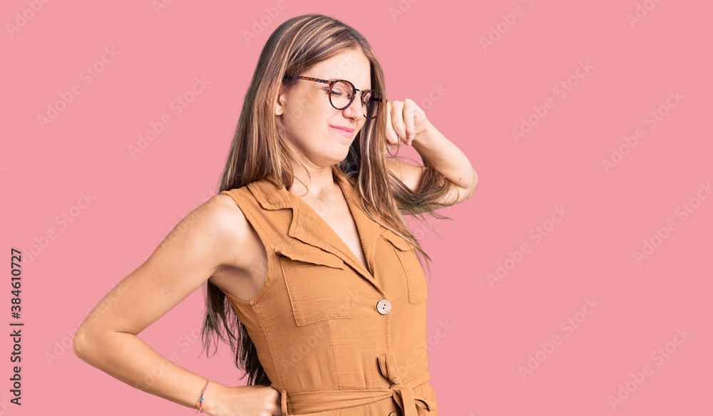 Young beautiful blonde woman wearing casual clothes and glasses stretching back, tired and relaxed, sleepy and yawning for early morning Young beautiful blonde woman wearing casual clothes and glasses stretching back, tired and relaxed, sleepy and yawning for early morning