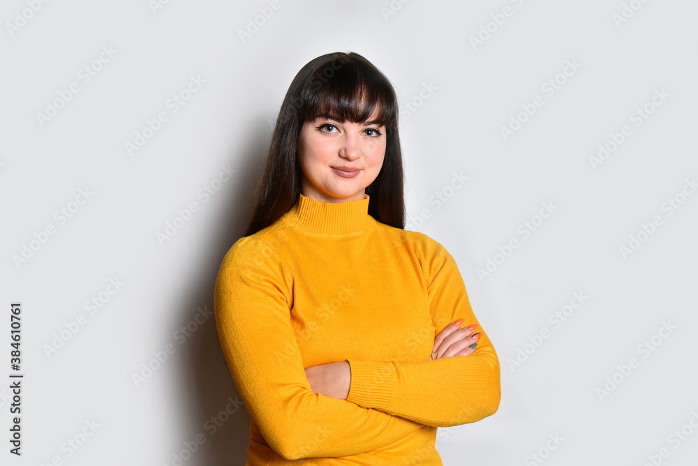 Obraz premium Young woman brunnette portrait posing with crossed arms.