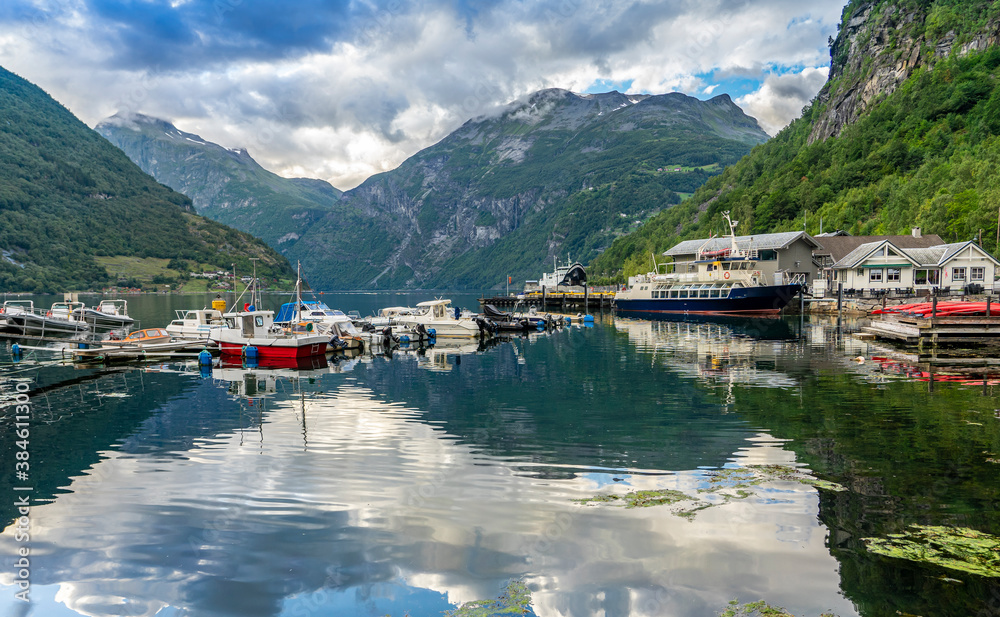 Urlaub in Süd-Norwegen: der epische Geiranger Fjord - der kleine Hafen vom Ort Geiranger mit bunten Booten und Fähre