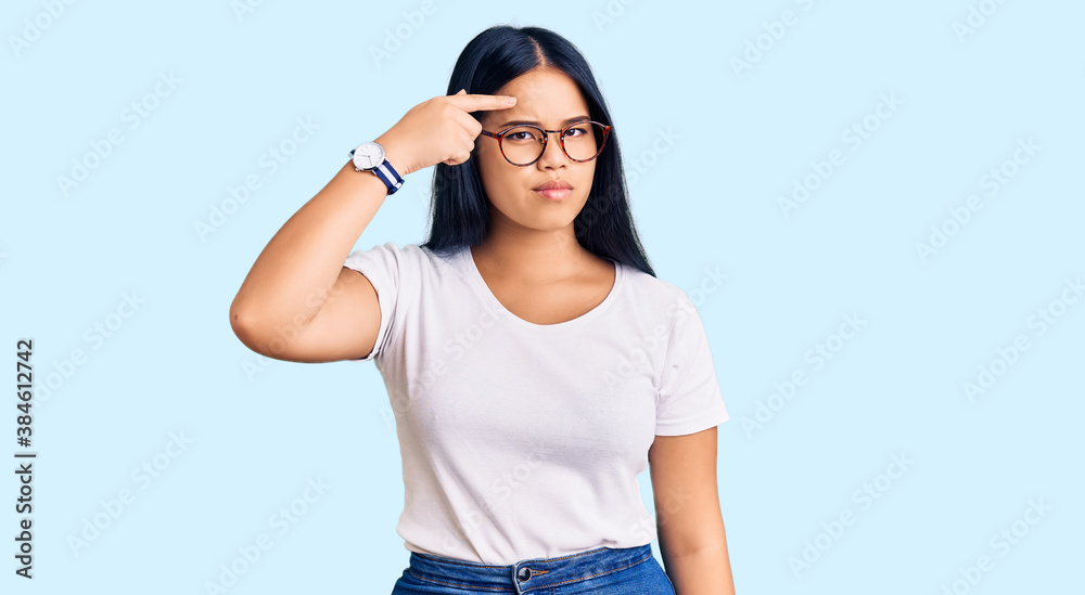 Obraz premium Young beautiful asian girl wearing casual clothes and glasses pointing unhappy to pimple on forehead, ugly infection of blackhead. acne and skin problem
