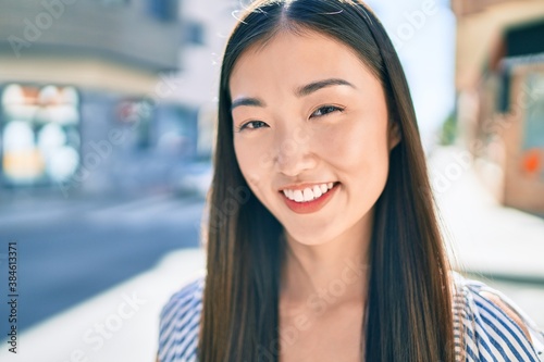 Wallpaper Mural Young chinese woman smiling happy walking at street of city. Torontodigital.ca