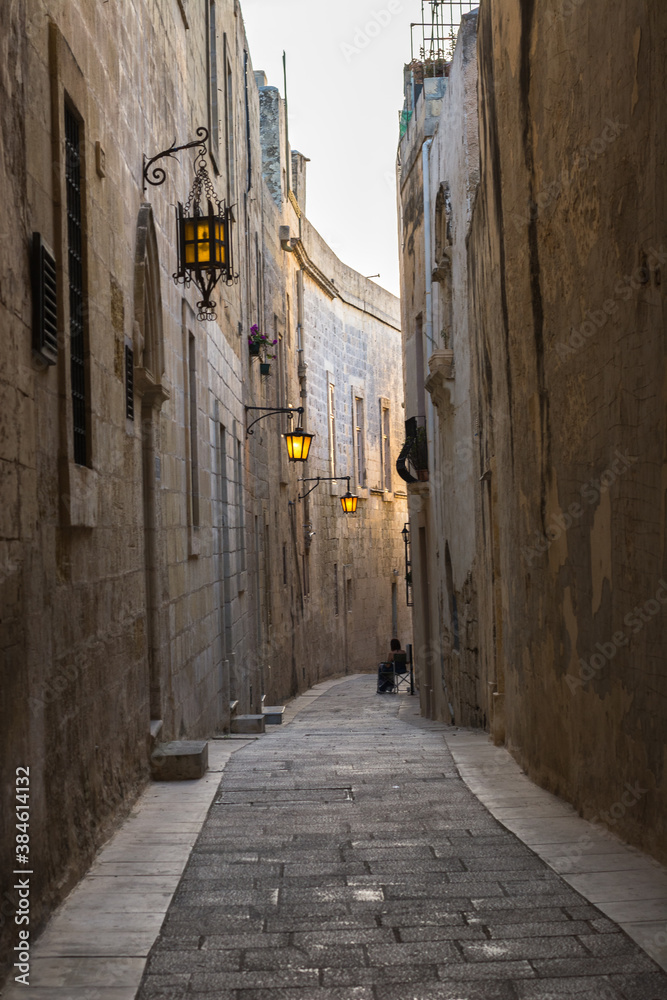 woman sitting alone in a narrow street of Mdina, Malta