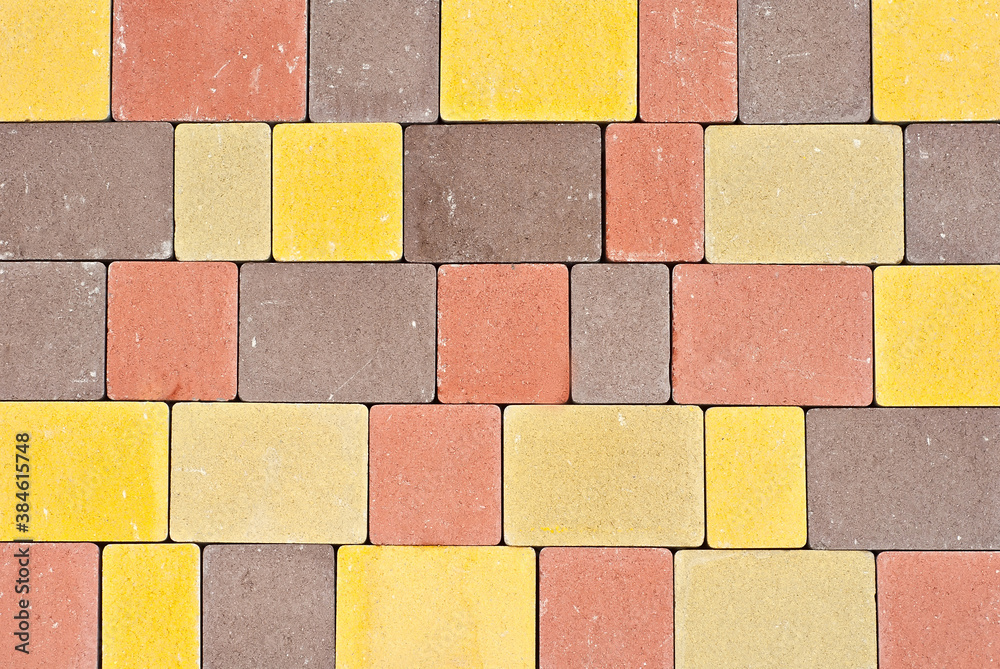 Cobblestone texture. The sidewalk tile is evenly folded. Multicolored cobblestones close up.