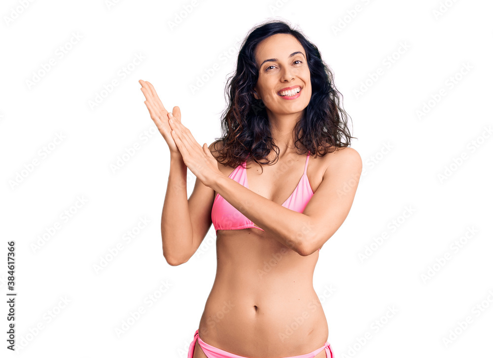 Young beautiful hispanic woman wearing bikini clapping and applauding happy and joyful, smiling proud hands together Young beautiful hispanic woman wearing bikini clapping and applauding happy and joyful, smiling proud hands together