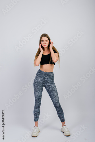 Full length portrait of smiling young fitness woman in perfect shape, studio shot