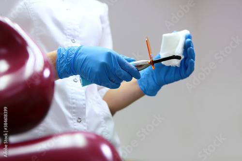 Dental assistant wipes the device for drying fillings with a napkin.Preparing the office for receiving patients. The concept of hygiene and sanitation. Unrecognizable person.