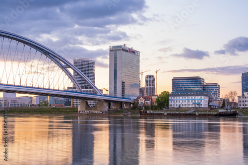 2020: Long exposure Apollo bridge over river Danube in Bratislava, Slovakia. Sunset, golden hour, dramatic skies. High rise buildings, travel destination