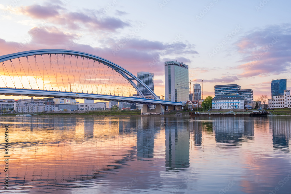 2020: Long exposure Apollo bridge over river Danube in Bratislava, Slovakia. Sunset, golden hour, dramatic skies. High rise buildings, travel destination 2020: Long exposure Apollo bridge over river Danube in Bratislava, Slovakia. Sunset, golden hour, dramatic skies. High rise buildings, travel destination