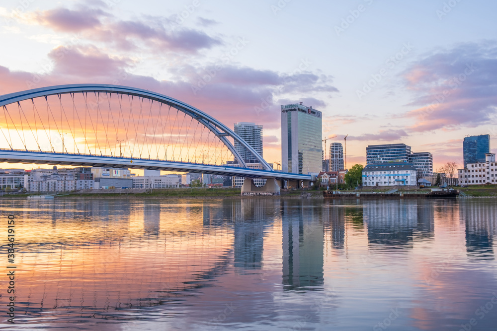 2020: Long exposure Apollo bridge over river Danube in Bratislava, Slovakia. Sunset, golden hour, dramatic skies. High rise buildings, travel destination