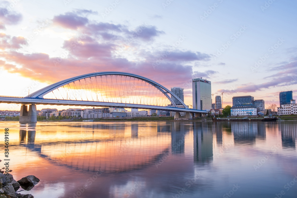 Obraz premium 2020: Long exposure Apollo bridge over river Danube in Bratislava, Slovakia. Sunset, golden hour, dramatic skies. High rise buildings, travel destination