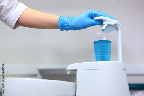 Disinfection of dental equipment before receiving patients. The concept of sanitation and hygiene in the clinic.Unrecognizable photo. Only hands in protective gloves.