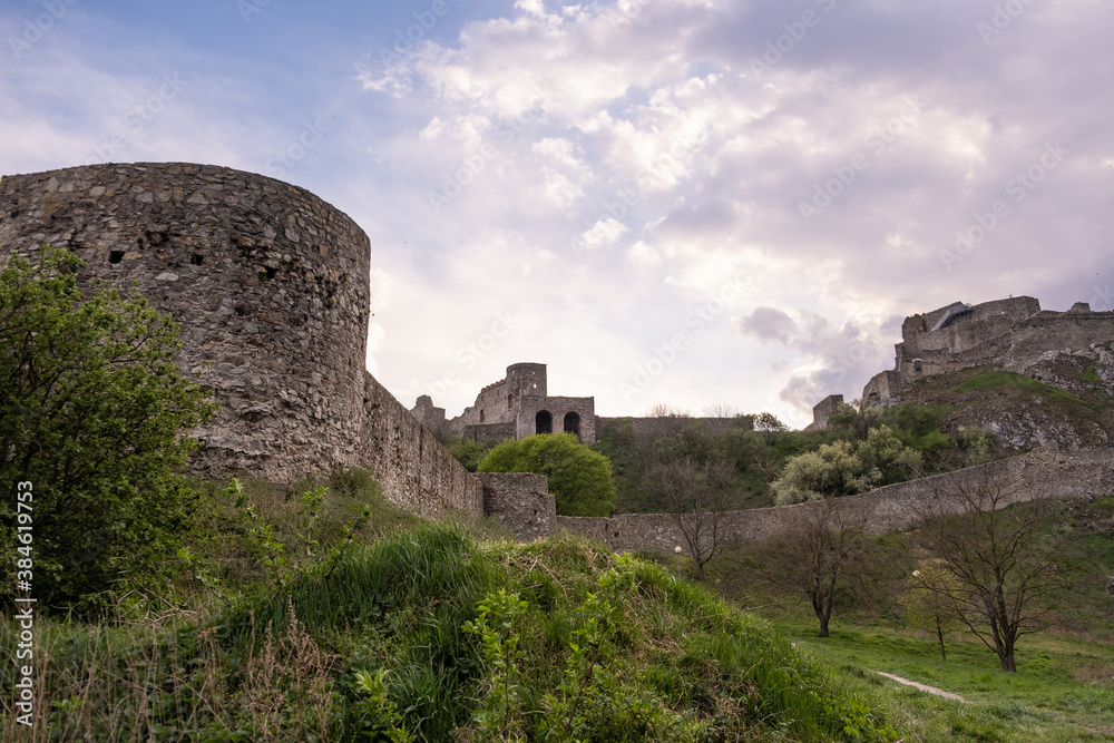 Devin castle ruins against cloudy blue sky. Bratislava, Slovakia. Medieval castle remnants, popular tourist spot, travel destination. Devinsky hrad