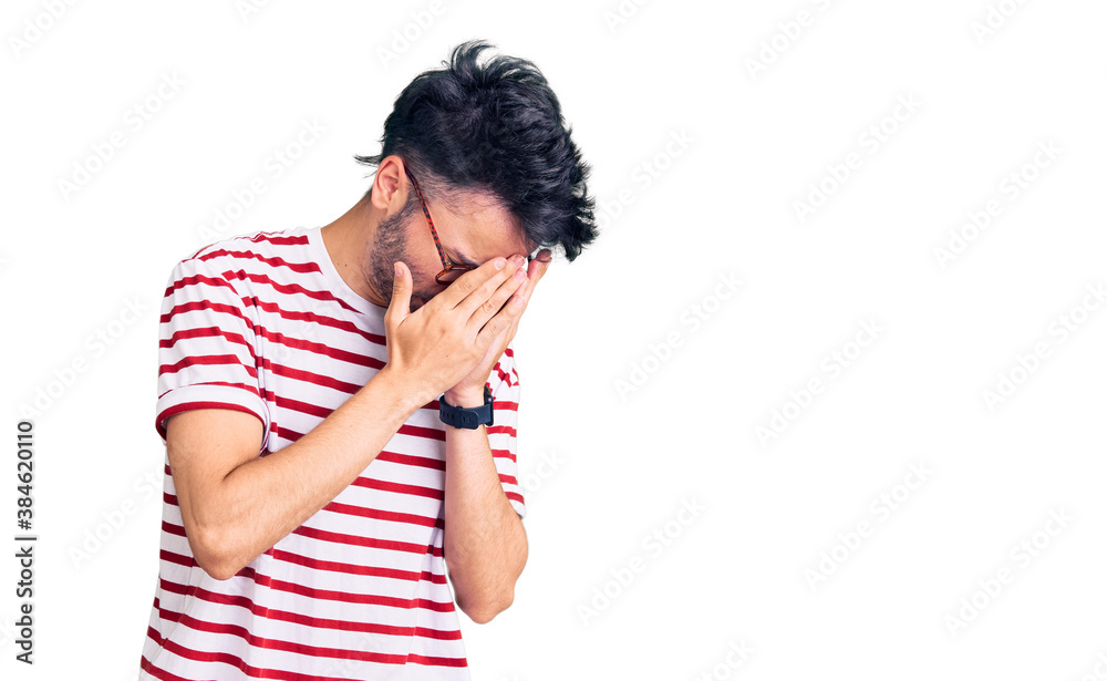 Young hispanic man wearing casual clothes with sad expression covering face with hands while crying. depression concept. Young hispanic man wearing casual clothes with sad expression covering face with hands while crying. depression concept.