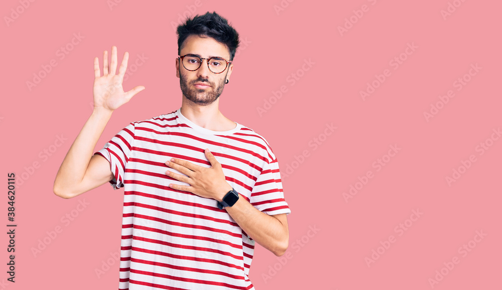 Fototapeta premium Young hispanic man wearing casual clothes swearing with hand on chest and open palm, making a loyalty promise oath