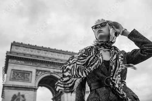 Photography Outdoor monochrome autumn fashion portrait of elegant, luxury lady wearing trendy boucle blazer, wide leather belt, animal, zebra print silk scarf, posing near Triumphal Arch in Paris