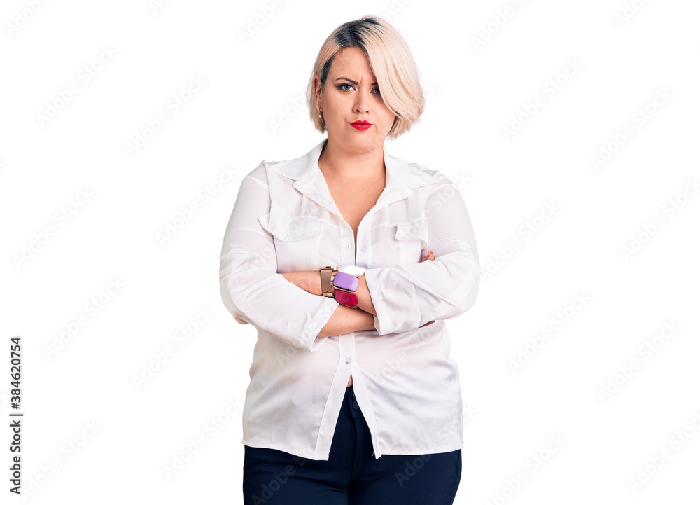 Young blonde plus size woman wearing casual shirt skeptic and nervous, disapproving expression on face with crossed arms. negative person. Young blonde plus size woman wearing casual shirt skeptic and nervous, disapproving expression on face with crossed arms. negative person.