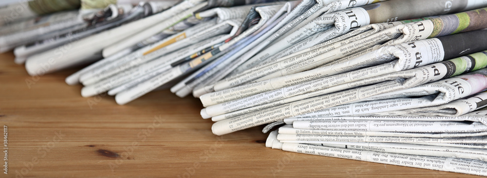 pile of newspapers on a wooden table pile of newspapers on a wooden table