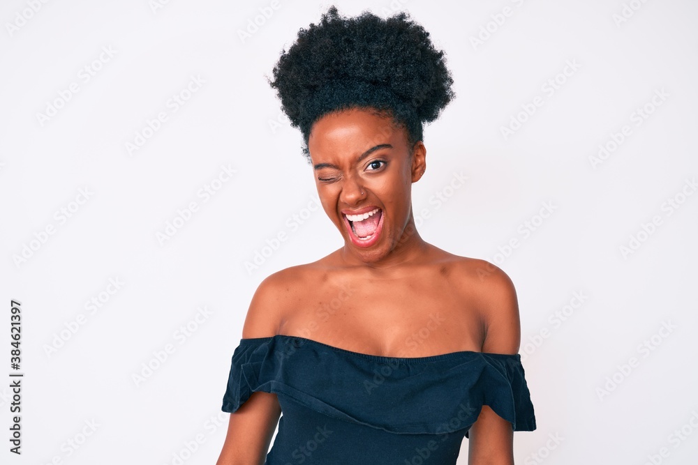 Young african american woman wearing casual clothes winking looking at the camera with sexy expression, cheerful and happy face. Young african american woman wearing casual clothes winking looking at the camera with sexy expression, cheerful and happy face.